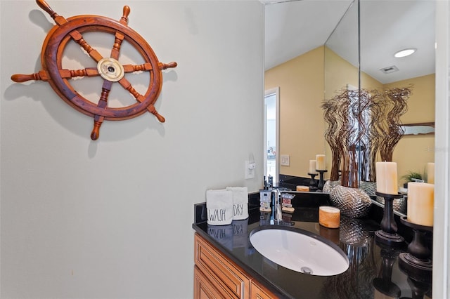 bathroom featuring vanity and lofted ceiling