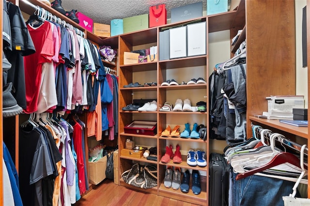 walk in closet with light hardwood / wood-style floors