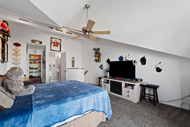 bedroom with ceiling fan, dark carpet, lofted ceiling, and connected bathroom