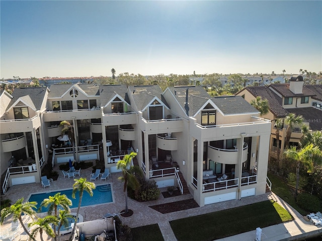 rear view of house featuring a balcony and a patio