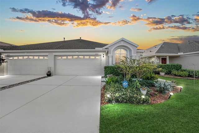 view of front of home featuring a garage and a lawn