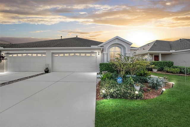 view of front of home with a yard and a garage