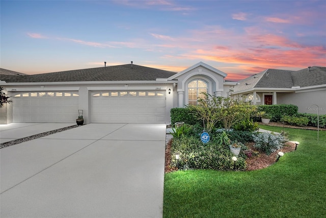 ranch-style home with a yard and a garage