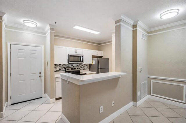 4323 Bayside Village Dr Unit 105, Tampa, FL 33615 - kitchen with appliances with stainless steel finishes, light tile patterned floors, ornamental molding, decorative backsplash, and white cabinetry