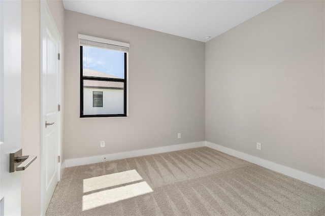 spare room featuring light colored carpet