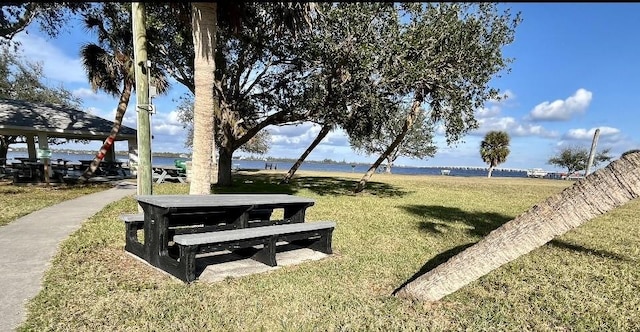 surrounding community with a gazebo, a water view, and a lawn