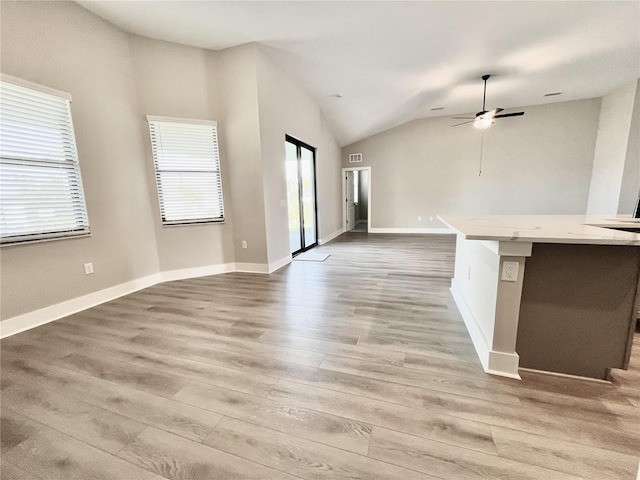 unfurnished living room featuring vaulted ceiling, ceiling fan, and hardwood / wood-style floors