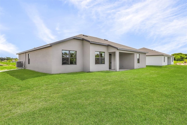 back of property featuring a lawn and central air condition unit