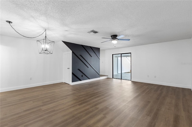 spare room with ceiling fan with notable chandelier, a textured ceiling, and dark hardwood / wood-style floors