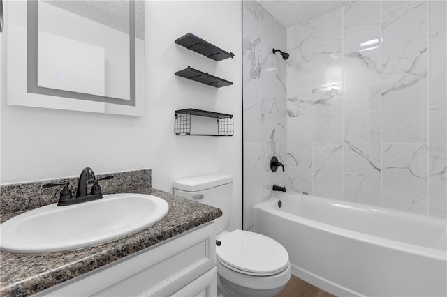 full bathroom featuring vanity, tiled shower / bath, a textured ceiling, and toilet