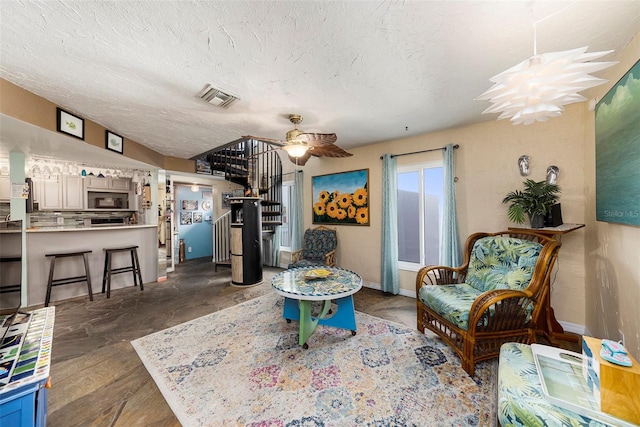 sitting room with a textured ceiling and ceiling fan