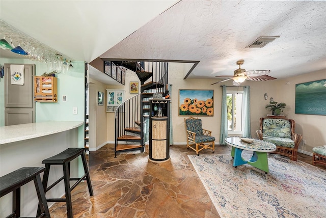 interior space featuring ceiling fan and a textured ceiling