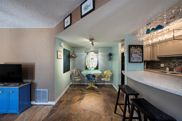 dining space with sink and a textured ceiling