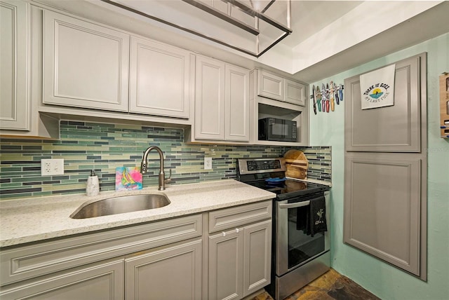 kitchen featuring sink, light stone counters, decorative backsplash, and electric range