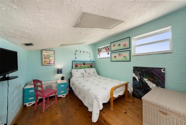 bedroom with a textured ceiling and dark wood-type flooring