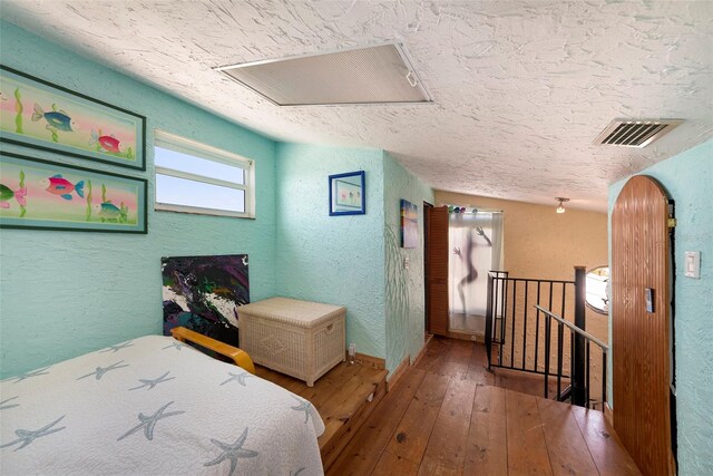 bedroom featuring hardwood / wood-style floors and a textured ceiling