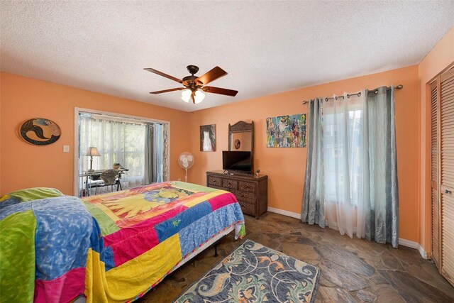 bedroom with a closet, ceiling fan, and a textured ceiling