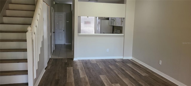 6212 Bayside Key Dr, Tampa, FL 33615 - spare room with stairs, dark wood finished floors, and baseboards