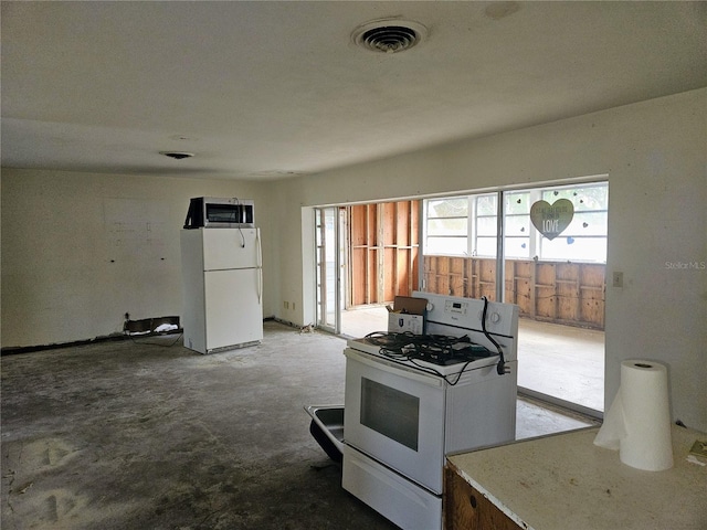 kitchen featuring white appliances and light carpet