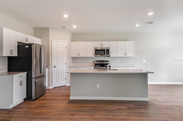 kitchen featuring dark hardwood / wood-style floors, a kitchen island with sink, stainless steel appliances, and white cabinets