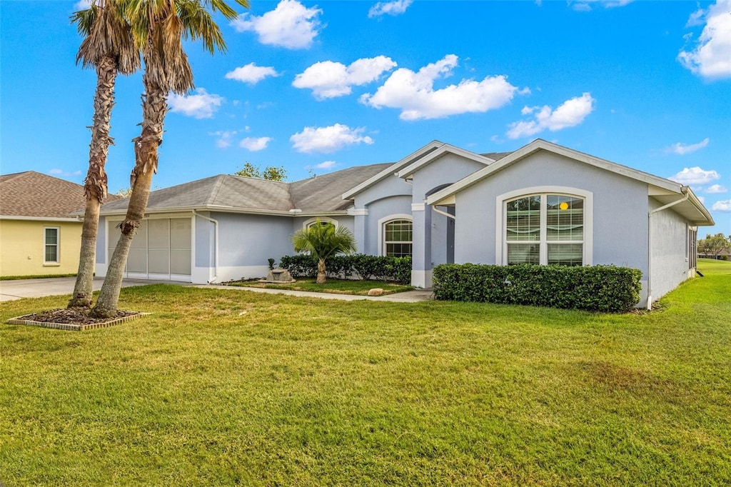 ranch-style house featuring a front lawn and a garage