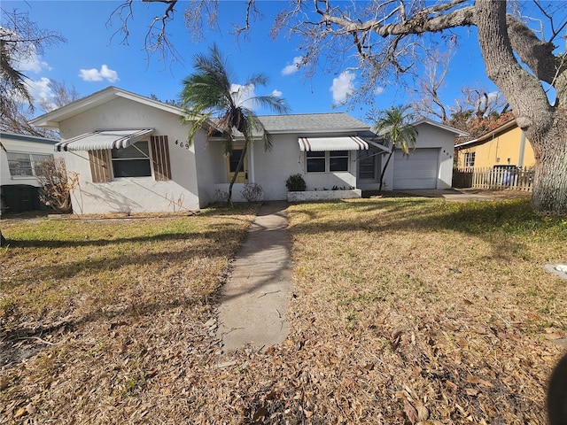 ranch-style home featuring a garage and a front lawn