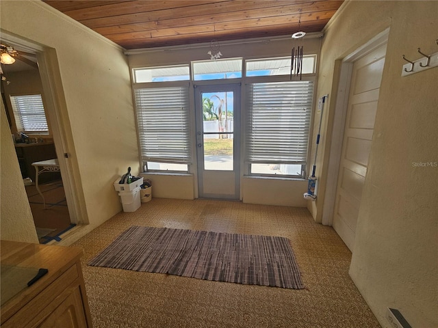 entryway featuring ornamental molding, light carpet, ceiling fan, and wooden ceiling