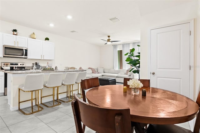 tiled dining room featuring ceiling fan