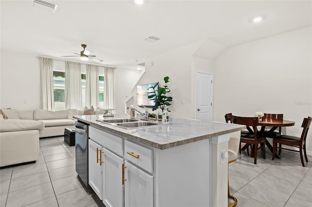 kitchen featuring ceiling fan, sink, a center island with sink, and light tile patterned floors