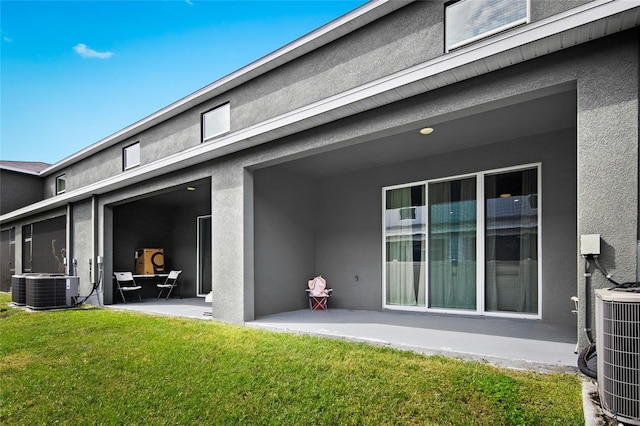 rear view of property with a patio area, central AC, and a yard