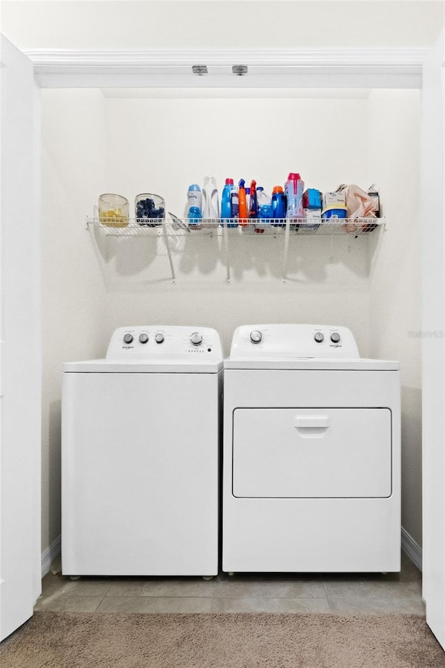 laundry room featuring washing machine and clothes dryer and light tile patterned floors