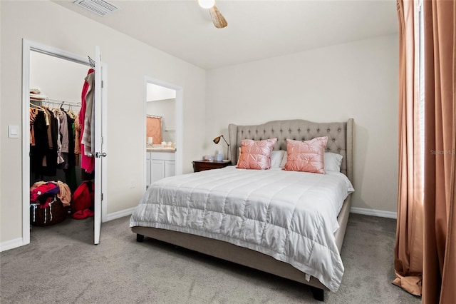 bedroom featuring carpet flooring, a walk in closet, ensuite bath, a closet, and ceiling fan