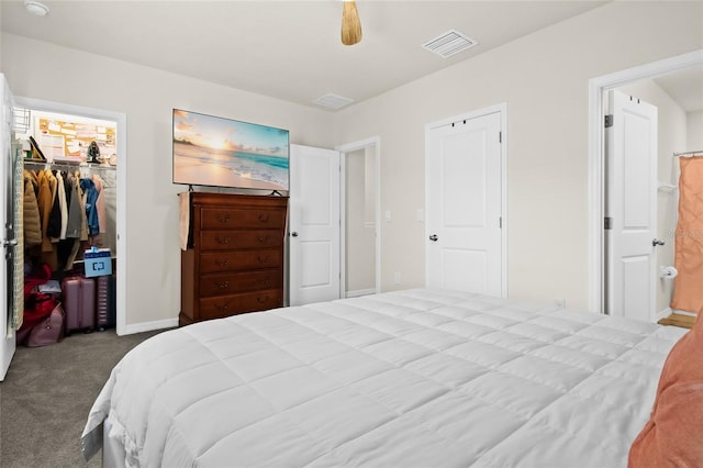 bedroom featuring ceiling fan, a spacious closet, carpet flooring, ensuite bathroom, and a closet