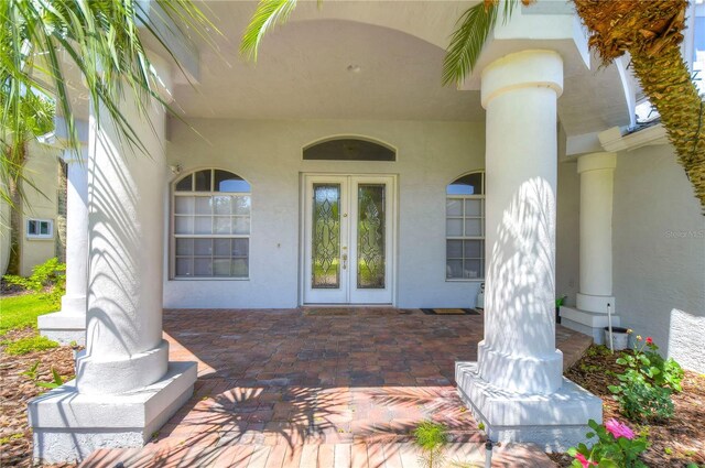 entrance to property featuring french doors and stucco siding