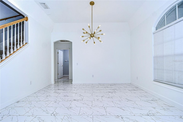 spare room featuring marble finish floor, visible vents, arched walkways, and a notable chandelier