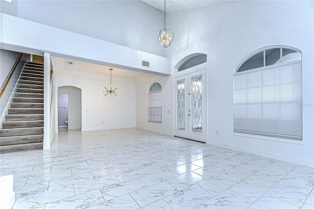 foyer with marble finish floor, french doors, visible vents, a chandelier, and stairs