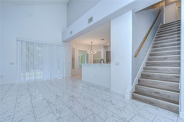 unfurnished room featuring a chandelier, visible vents, baseboards, stairs, and marble finish floor