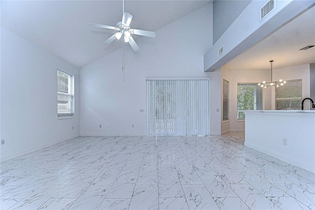 empty room featuring ceiling fan with notable chandelier, marble finish floor, and visible vents