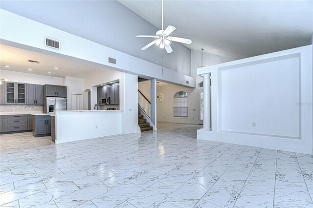 unfurnished living room featuring marble finish floor, visible vents, ceiling fan, and stairway