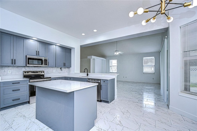 kitchen with a kitchen island, marble finish floor, appliances with stainless steel finishes, decorative backsplash, and pendant lighting