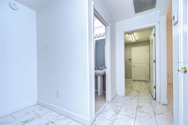 hall featuring marble finish floor, visible vents, and baseboards