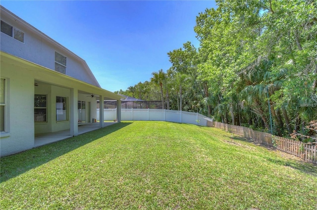 view of yard with a patio, a fenced backyard, and a ceiling fan