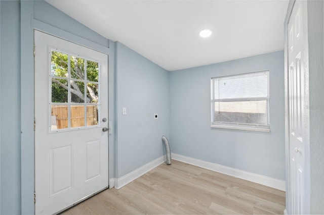 laundry area with hookup for an electric dryer and light wood-type flooring