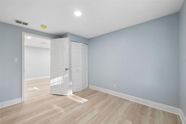 unfurnished bedroom featuring light hardwood / wood-style flooring and a closet