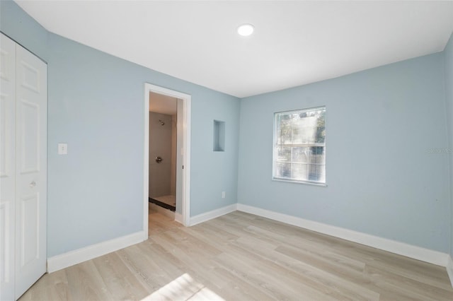 unfurnished bedroom featuring a closet and light hardwood / wood-style flooring