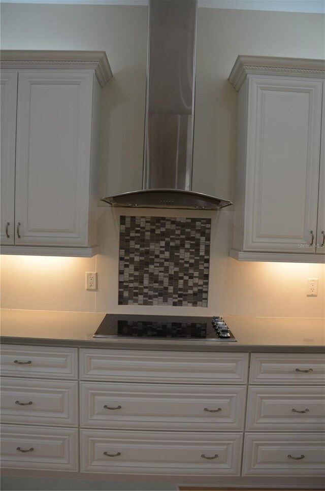 kitchen with white cabinetry, decorative backsplash, wall chimney exhaust hood, and stainless steel gas stovetop