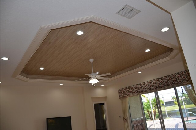 room details with a tray ceiling, wooden ceiling, ceiling fan, and crown molding