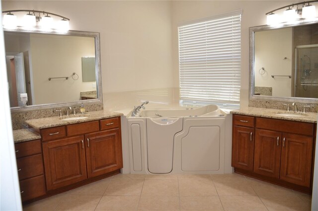 bathroom featuring a bath, vanity, and tile patterned flooring