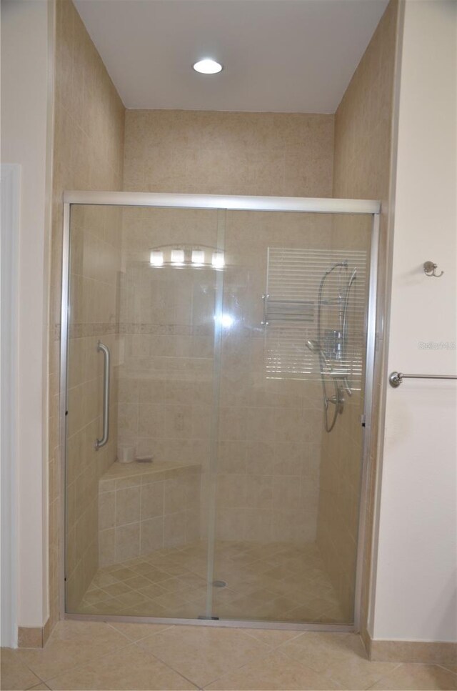 bathroom featuring a shower with shower door and tile patterned flooring