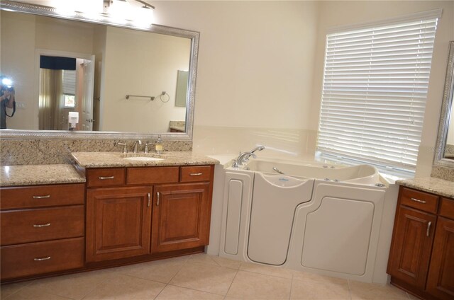 bathroom featuring vanity, tile patterned flooring, and a bathing tub